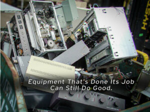 A large bin overflowing with outdated and dismantled electronic equipment, including servers and control panels. Overlaid text states, "Equipment That’s Done Its Job Can Still Do Good," promoting the idea of repurposing or donating old tech.